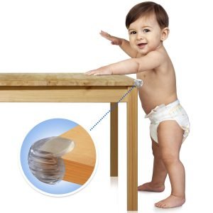 A baby leaning on a table fitted with furniture babyproof corner safety protector 